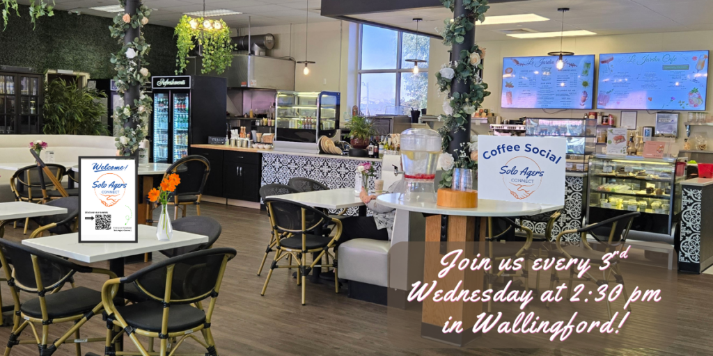 Photo of an inside of a cafe with the caption "join us every third Wednesday at 10 am in Wallingford!" On the table is a welcome sign for solo agers for the coffee social.