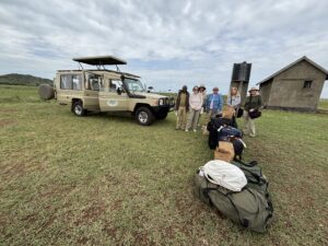 Group of women travelers on a safari in Africa iwth their luggage and jeep.