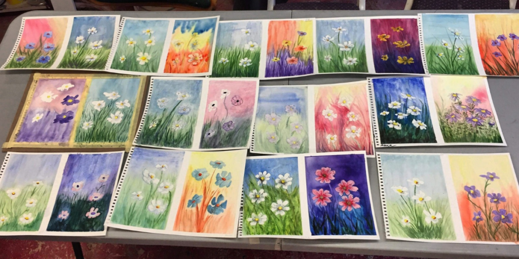 An image of watercolor flowers spread out on a table.